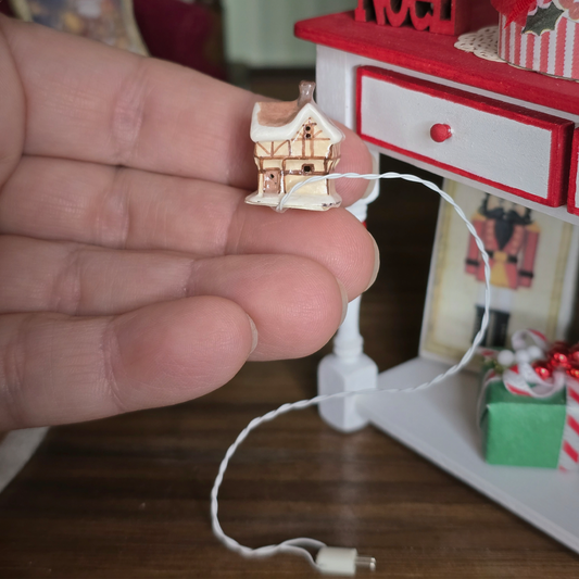 Dollhouse Miniature Light-Up English Cottage, held in a hand