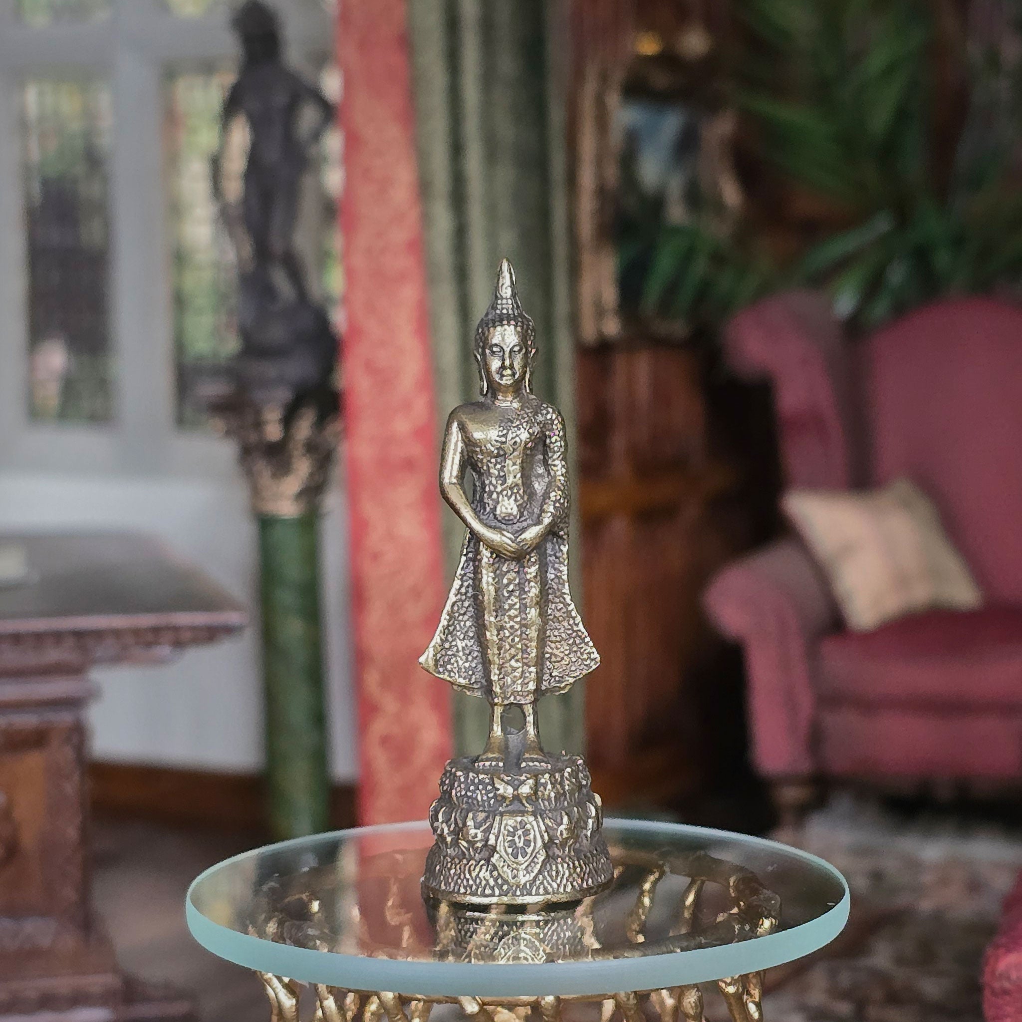 Decorative Buddha statue on a table in a room with furniture and decor.