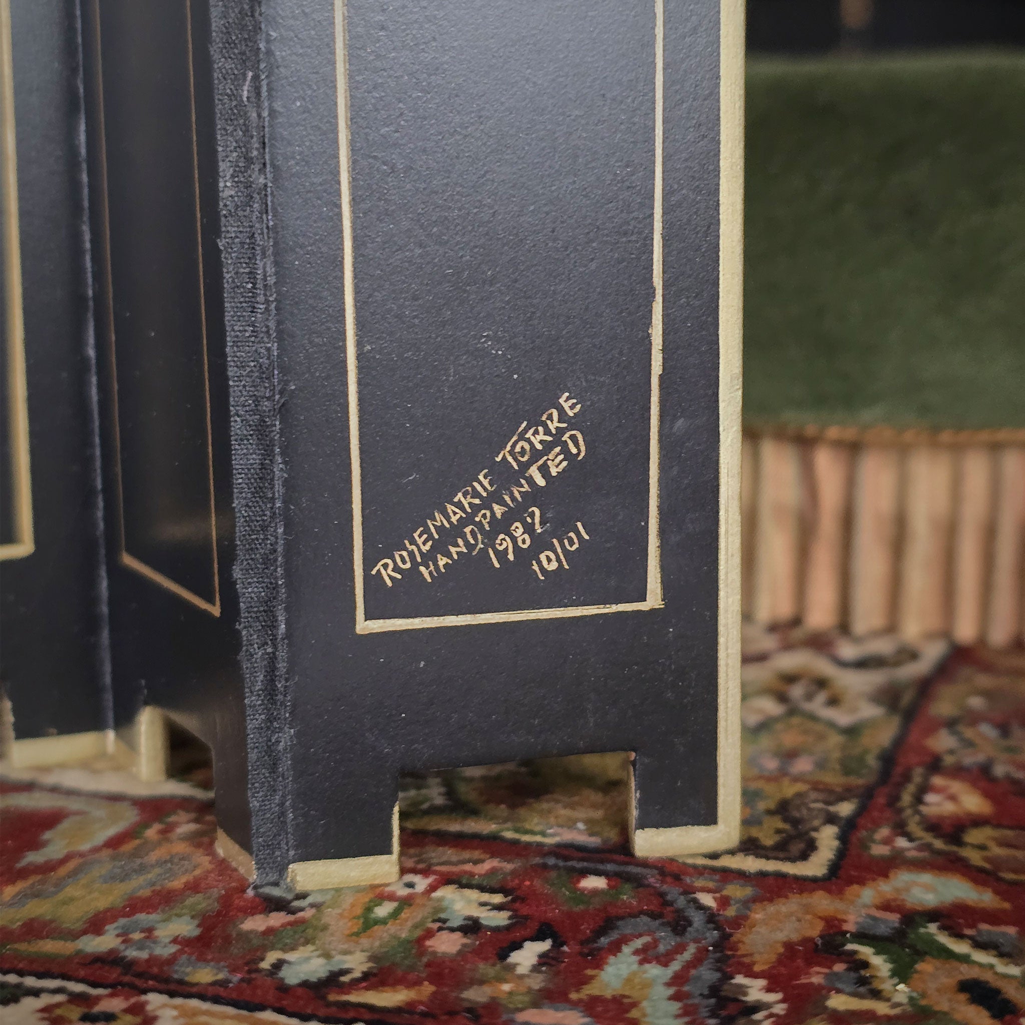 Close-up of a room divider screen with gold signature of artist Rosemarie Torre, 1982