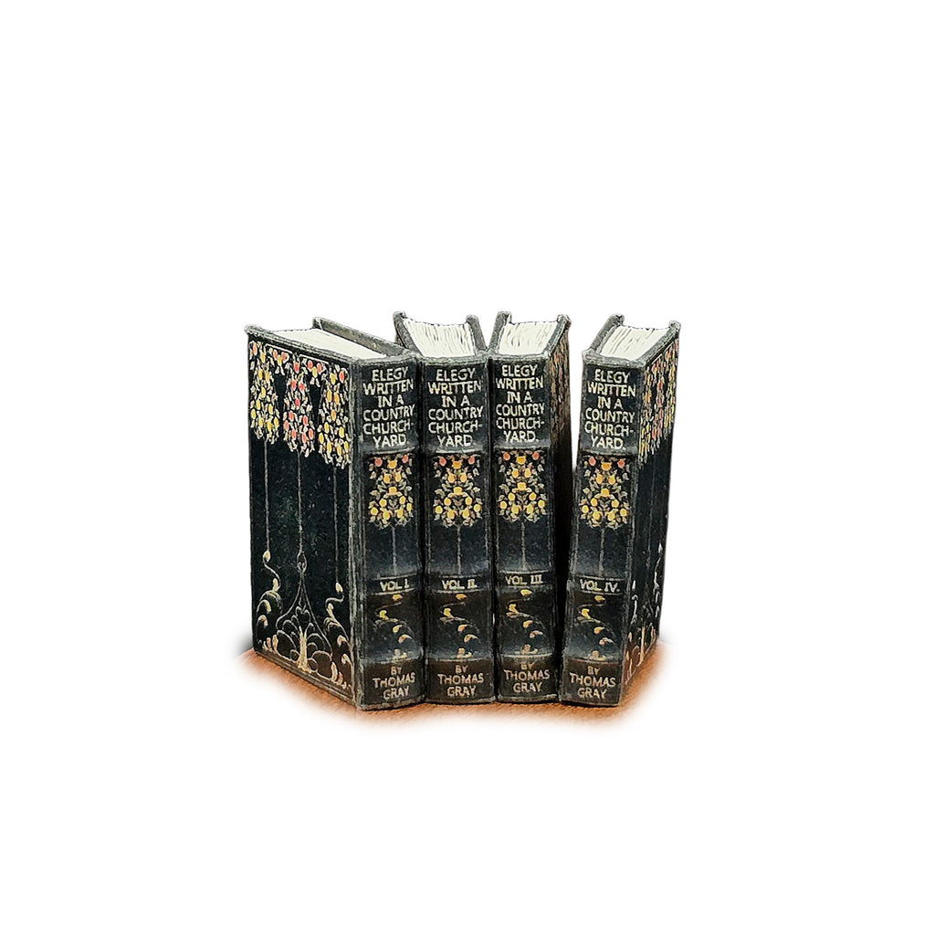 Set of four ornate books with decorative covers on a white background