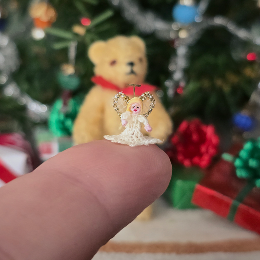 tiny angel tree topper for Christmas on a finger
