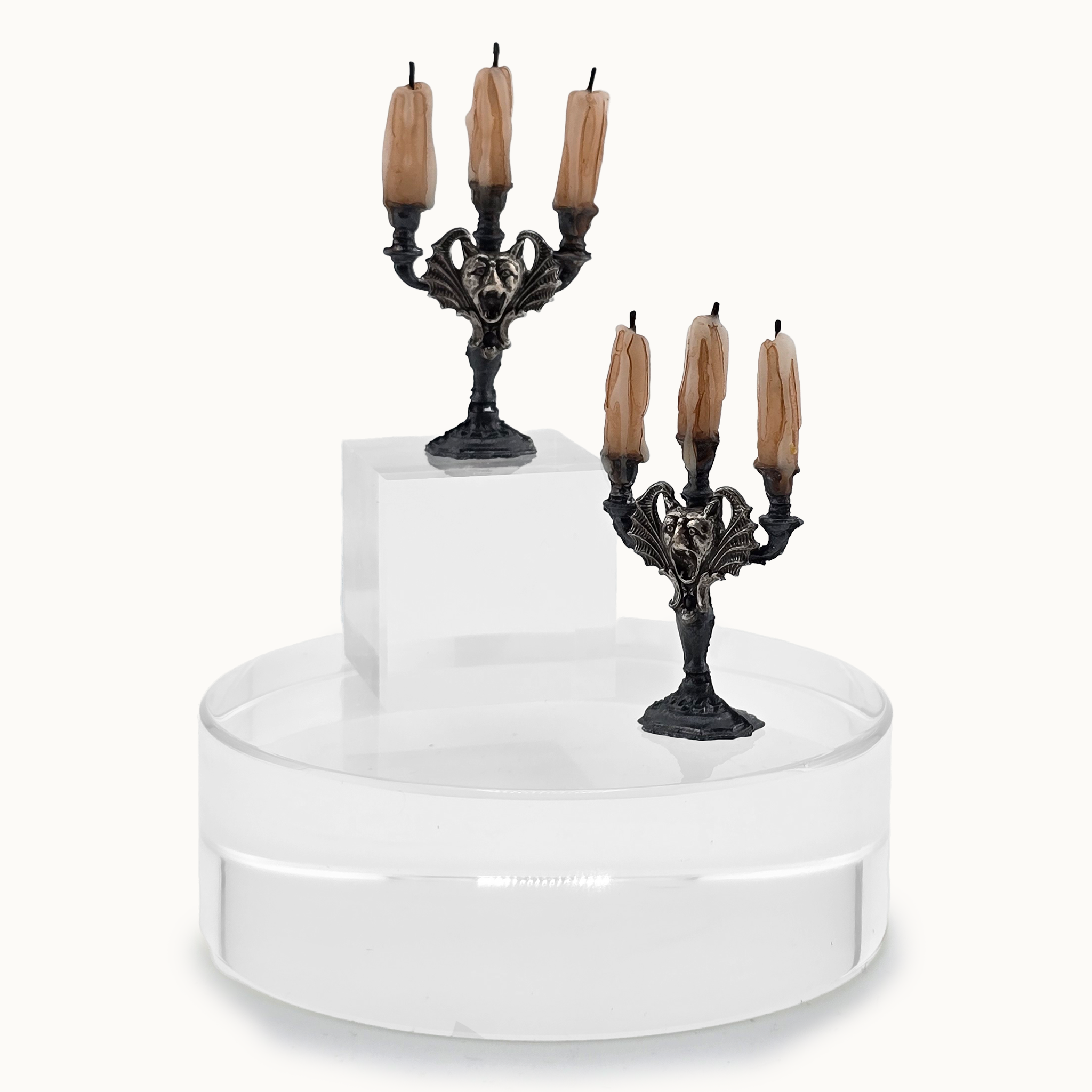 Decorative cake stand with candelabras and candles on a white background