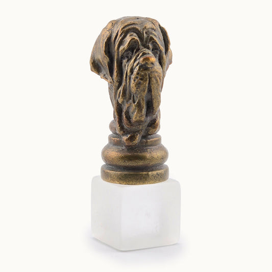 Decorative metal miniature bronze-colored dog sculpture on a white base