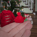 Load image into Gallery viewer, Dollhouse miniature red felted wool hat held in front of a decorated Christmas tree.

