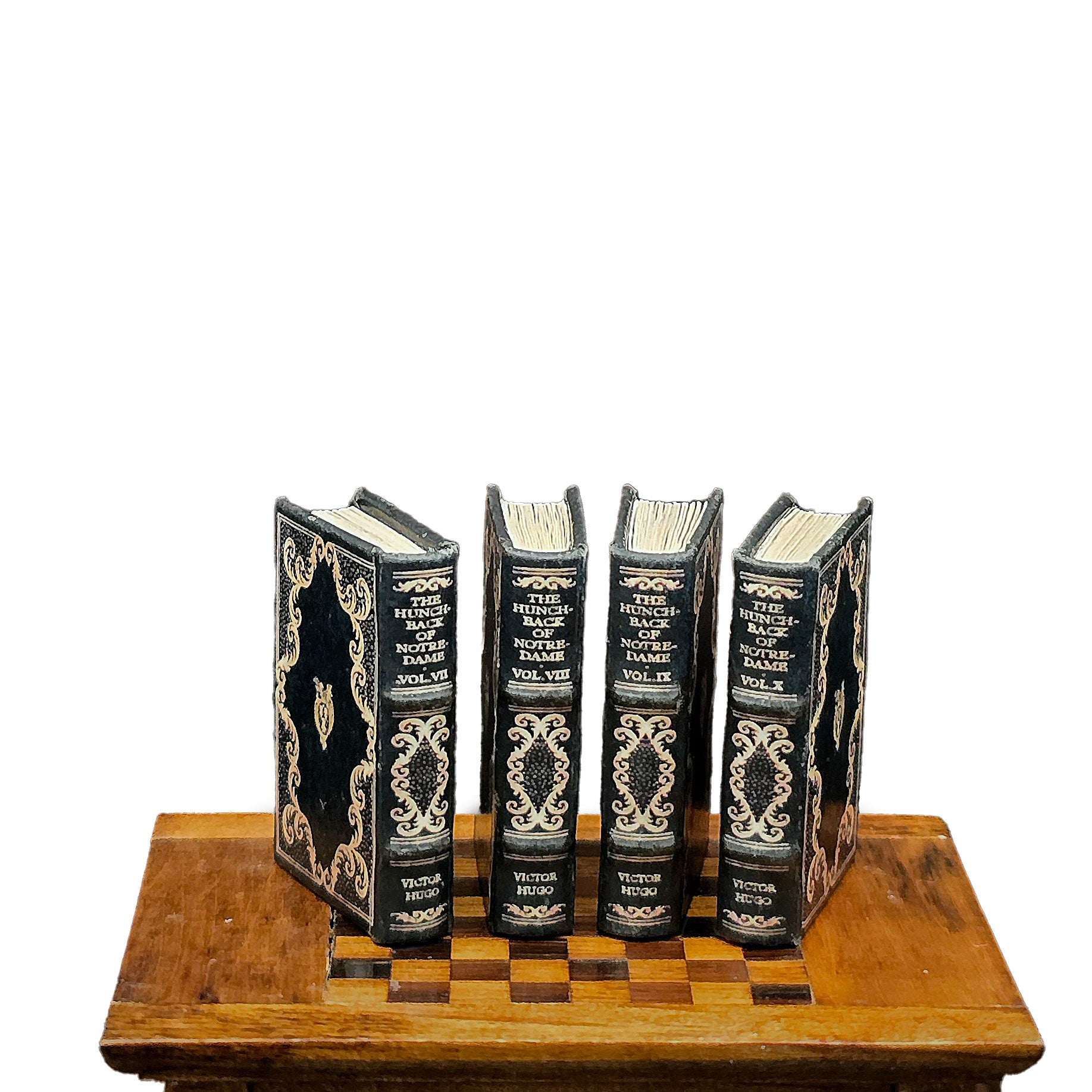 Set of four ornate books on a wooden stand with a white background