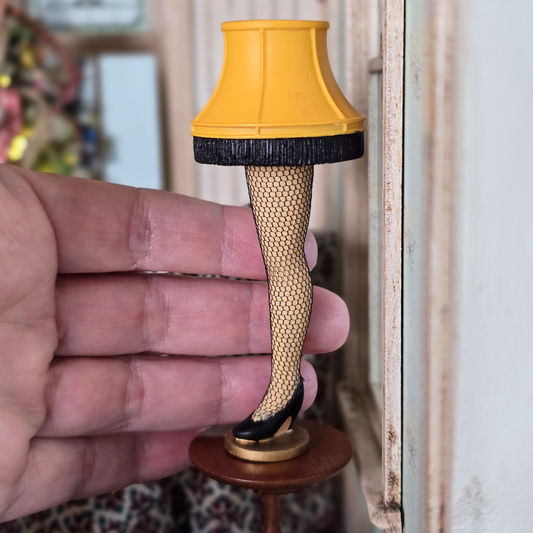 Miniature Leg Lamp – A Christmas Story Replica with a hand behind it