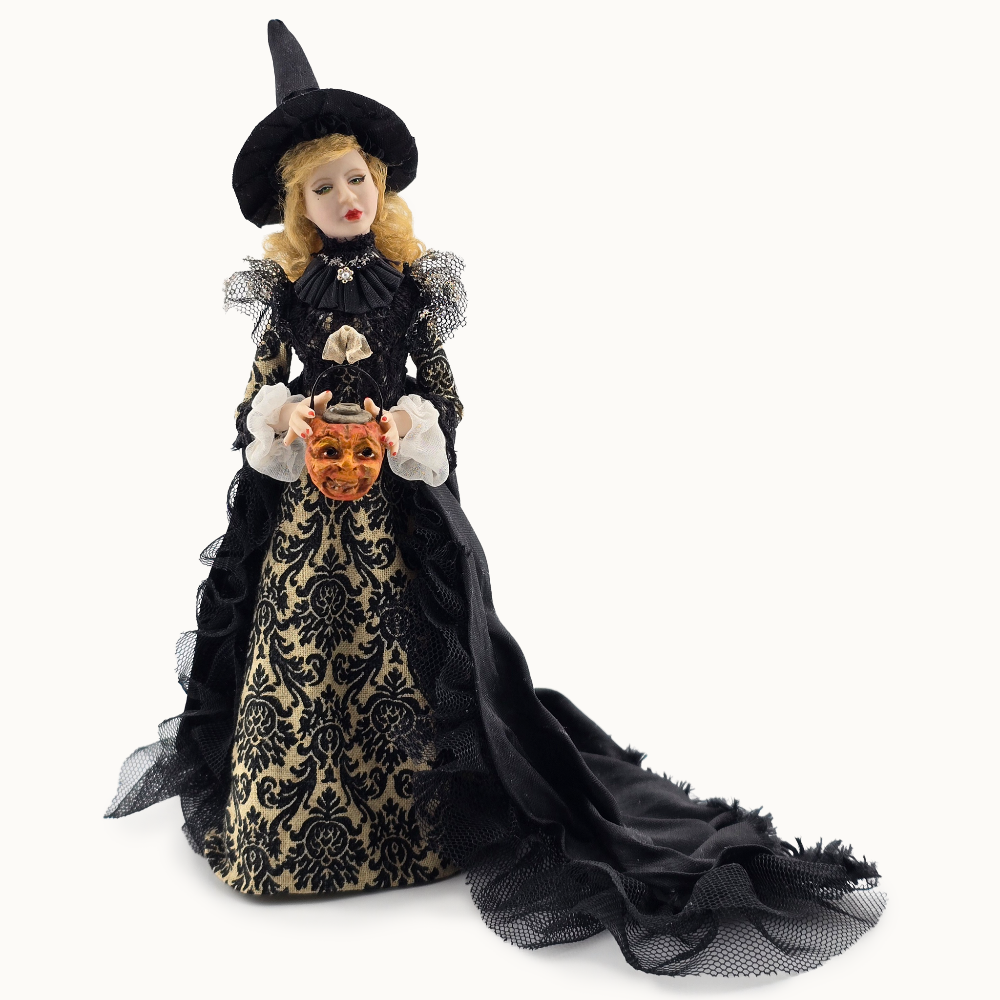 Halloween-themed doll in a black dress with a pumpkin, on a white background