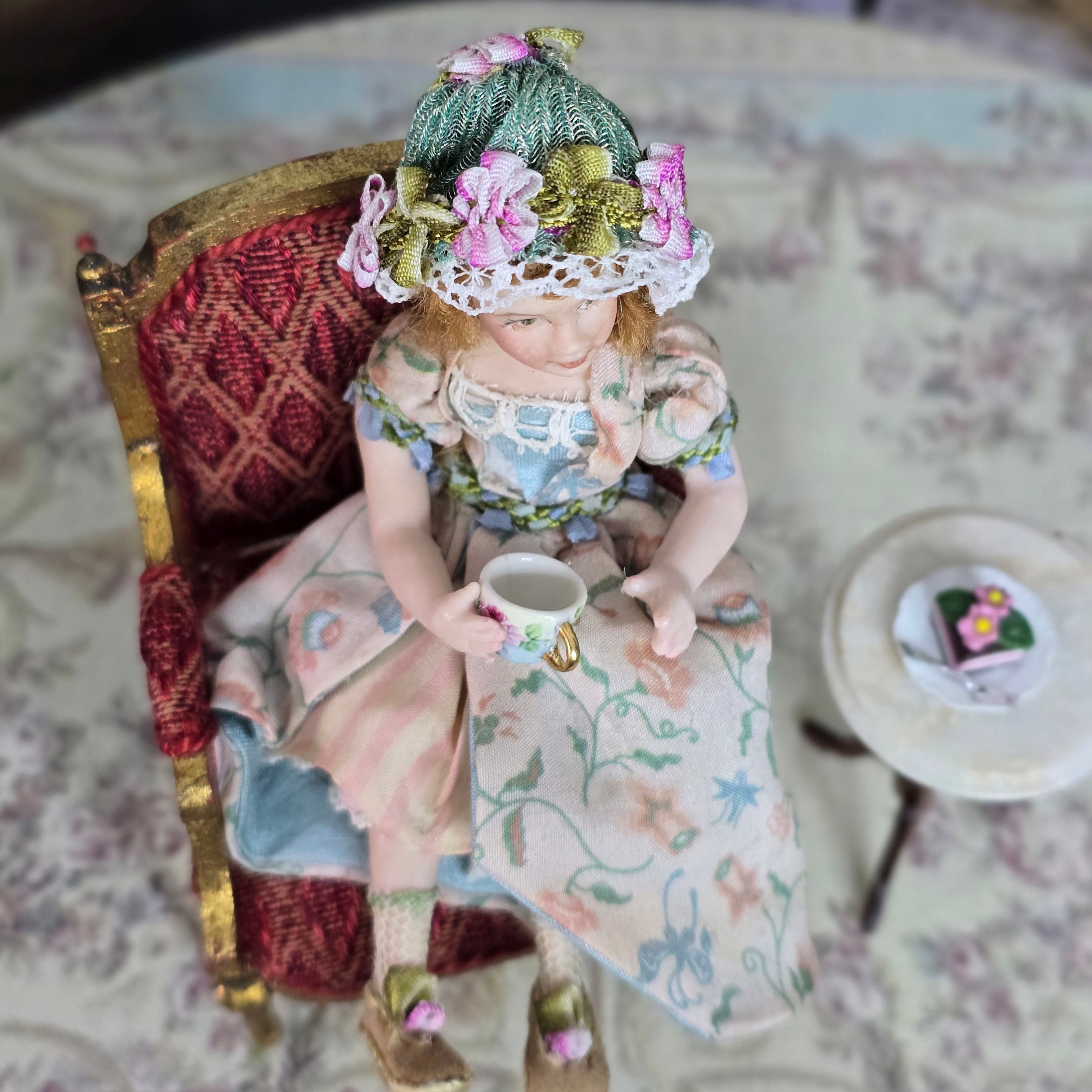 Seated Porcelain Little Girl Doll with Teacup, Green Silk Hat & Leather Shoes