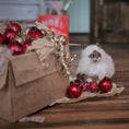 Load image into Gallery viewer, Cat among Christmas ornaments on a wooden surface with a blurred background
