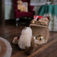 Load image into Gallery viewer, Small cat with a cardboard box containing Christmas ornaments on a wooden floor.
