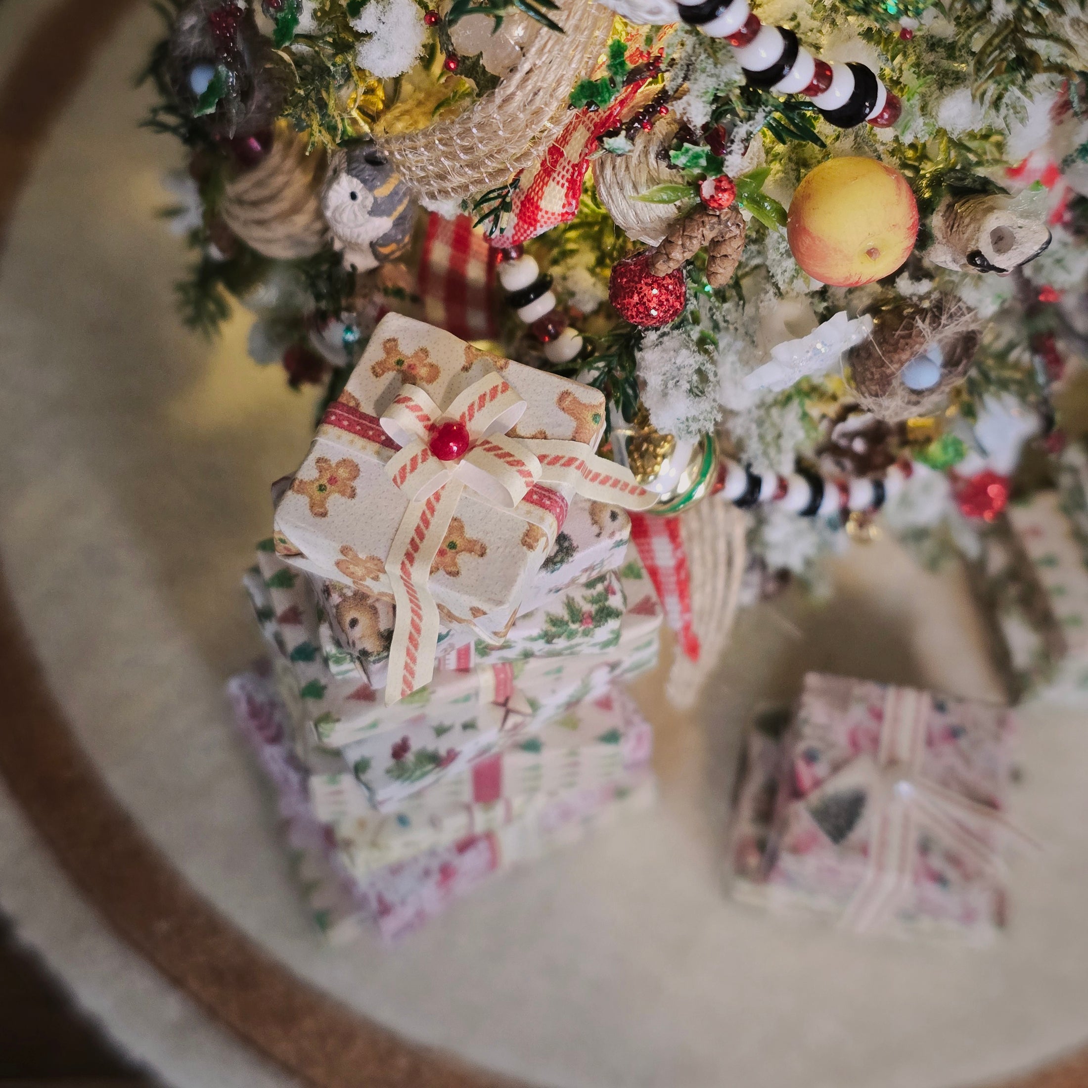 Stack of Christmas-themed cards with a decorated Christmas tree in the background