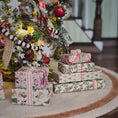 Load image into Gallery viewer, Stack of Christmas presents in front of a decorated tree
