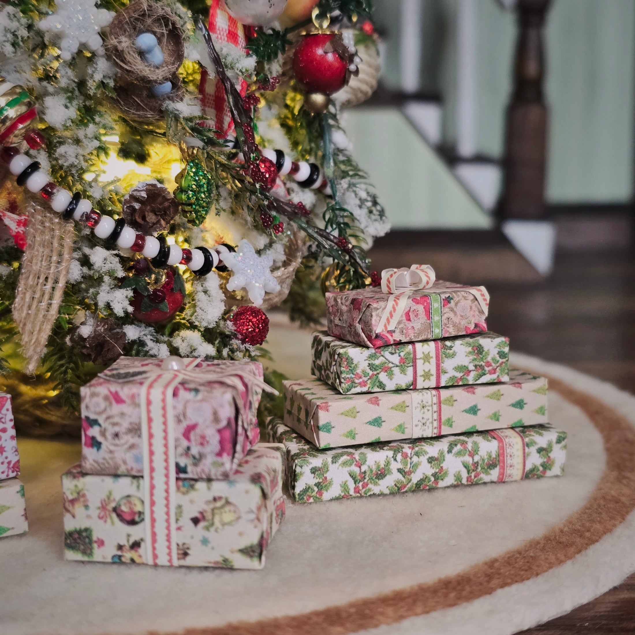 Stack of Christmas presents in front of a decorated tree