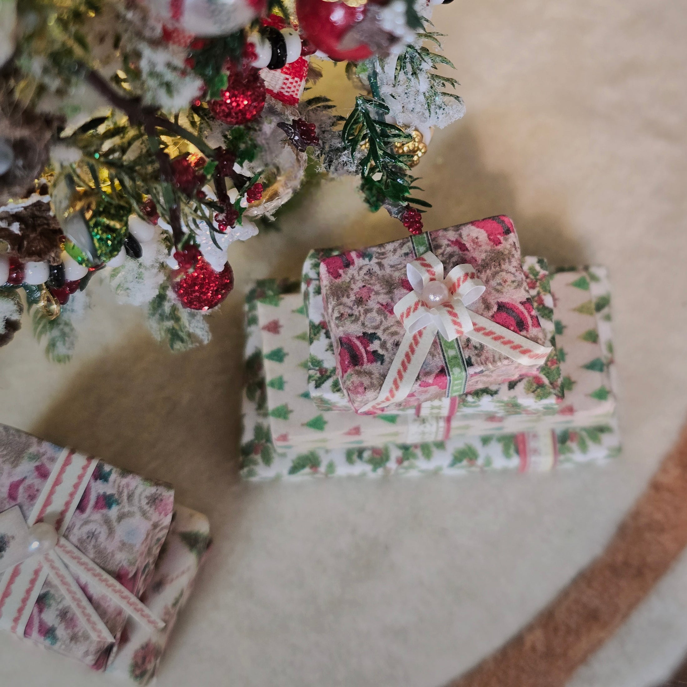Decorative Christmas presents under a tree with festive decorations.