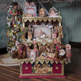 Load image into Gallery viewer, Decorative Christmas scene with figurines, teddy bears, and a small tree on a wooden surface.
