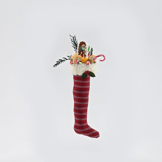 Decorative Christmas stocking with festive items on a light gray background