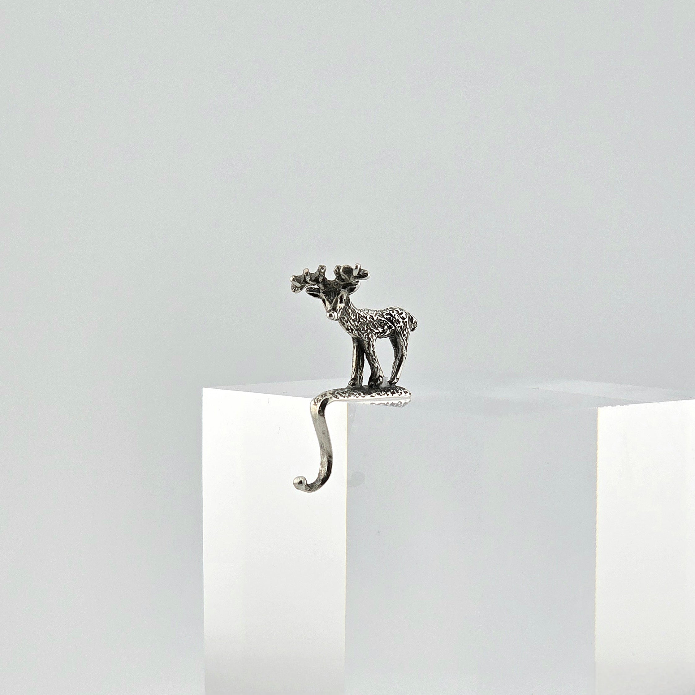 Miniature sterling reindeer stocking holder on a white background