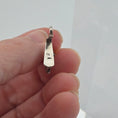 Load image into Gallery viewer, underside of Miniature sterling reindeer stocking holder held between fingers against a white background

