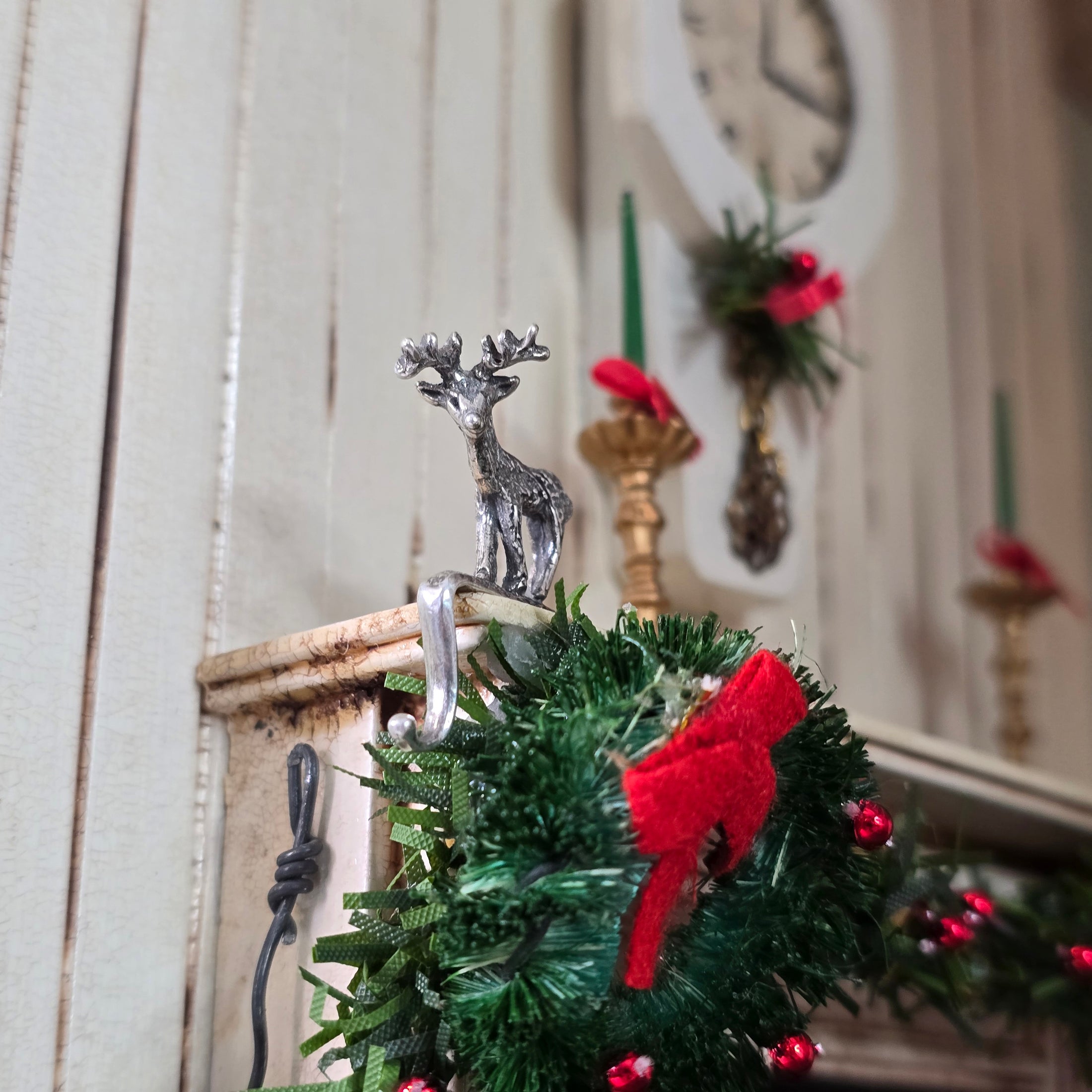 Miniature sterling reindeer stocking holder on a mantelpiece