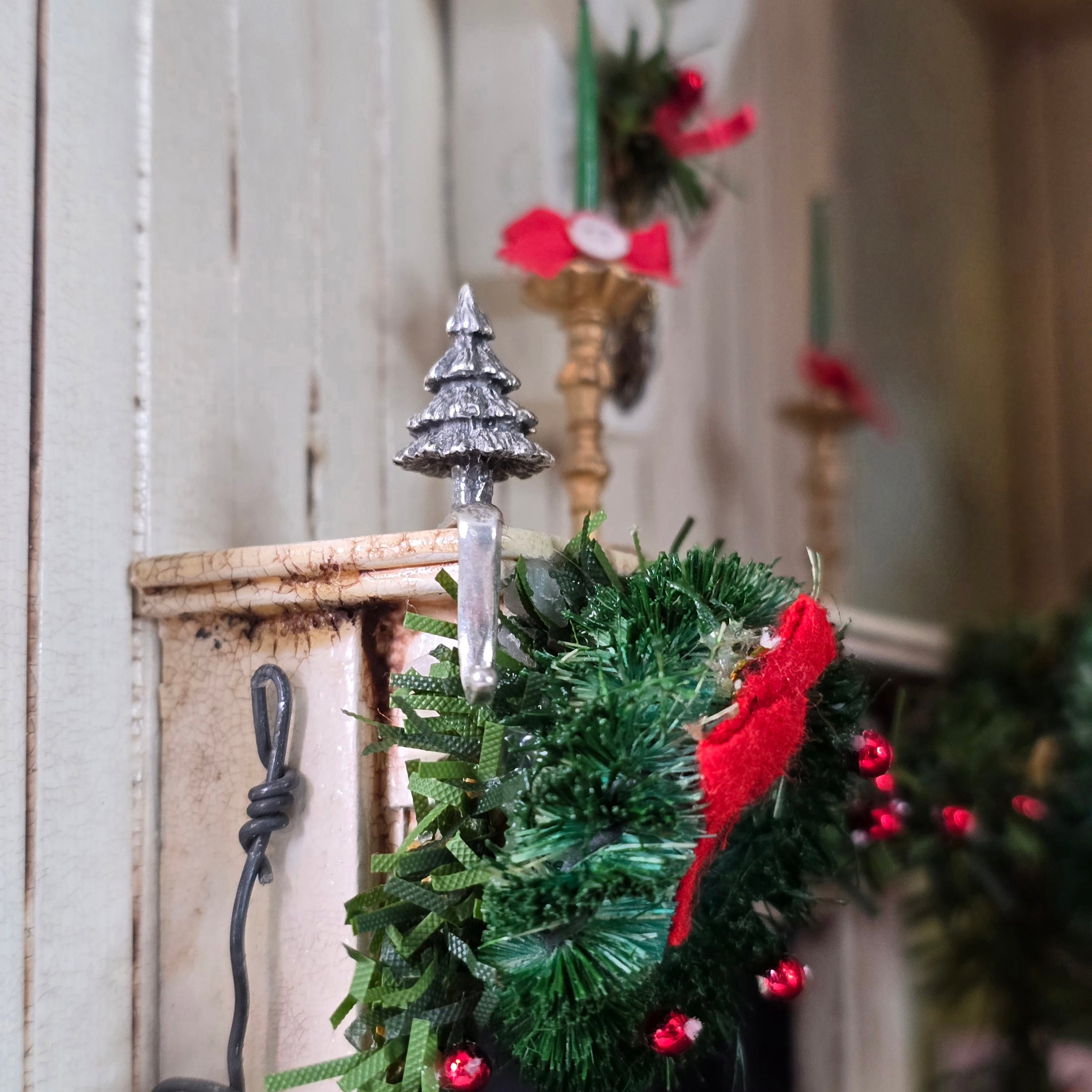 sterling silver Christmas tree stocking holder on corner of garland topped mantel