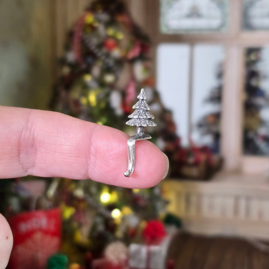 sterling silver Christmas tree stocking holder balancing on fingertip