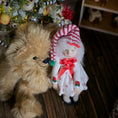 Load image into Gallery viewer, Teddy bear and  Christmas girl doll by artisan Carol McBride in front of a decorated Christmas tree
