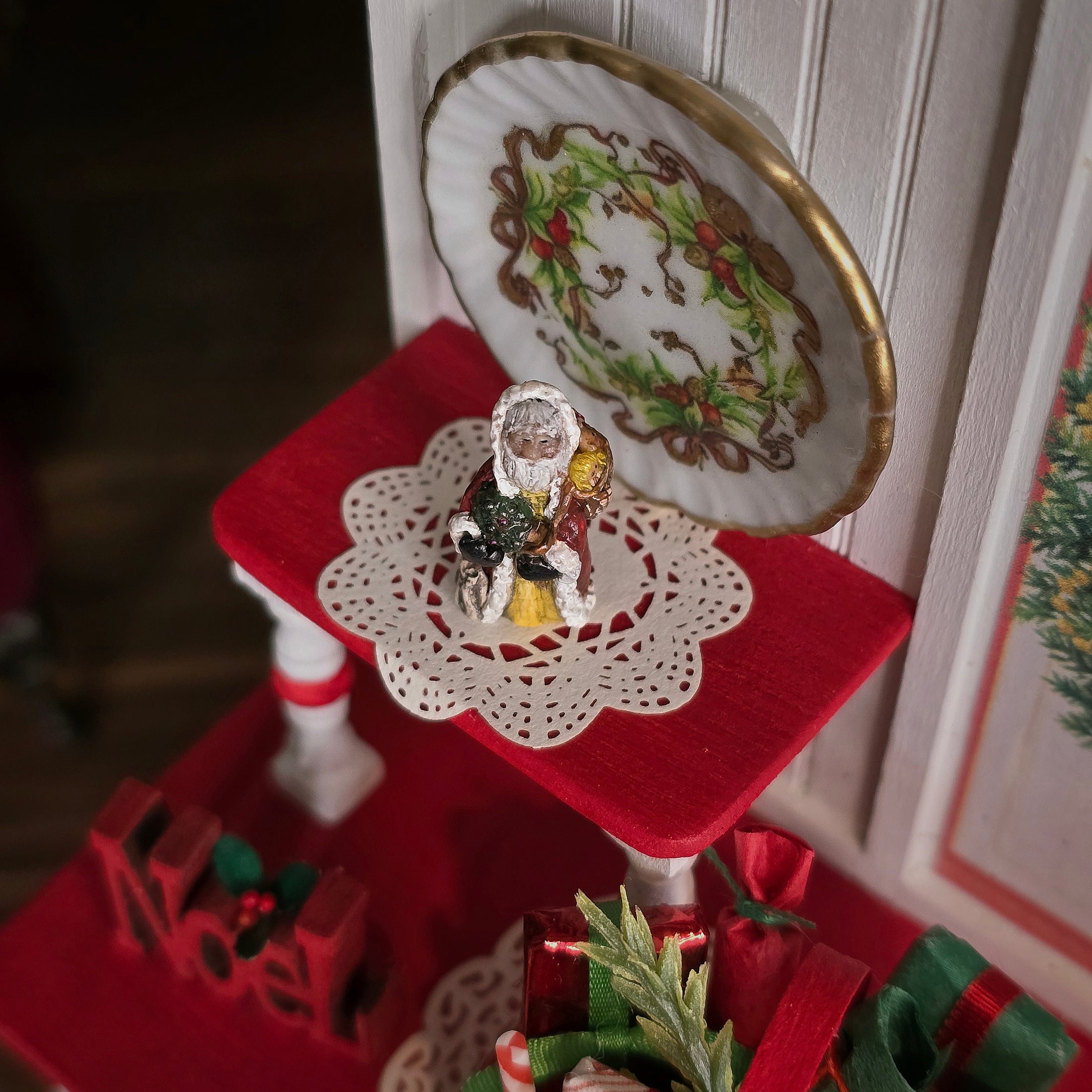 Old World Miniature Santa Figurine by Ann Anderson, top view on red accent table