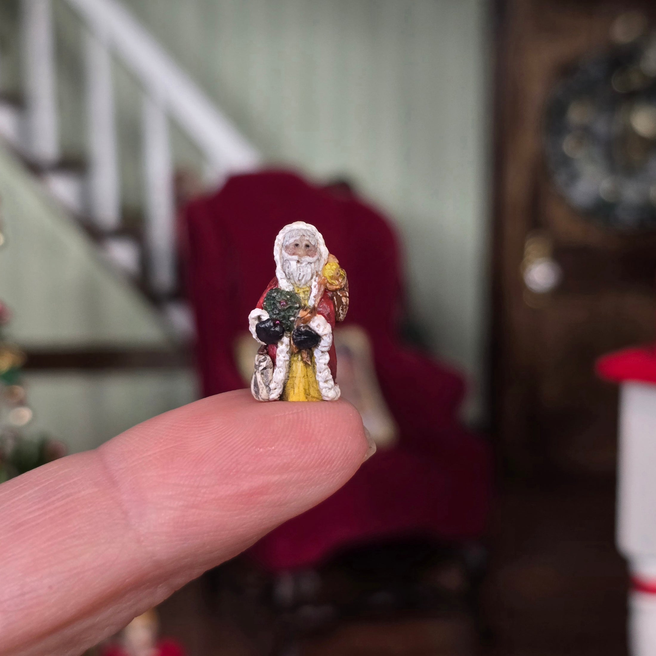 Old World Miniature Santa Figurine by Ann Anderson, balanced on a single finger