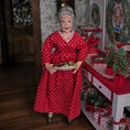 Load image into Gallery viewer, Lady doll in a red polka dot dress holding a plate of cookies in a festive room.
