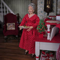 Load image into Gallery viewer, Doll in a red dress with white polka dots holding a tray in a festive room.
