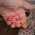 Load image into Gallery viewer, Yawning elf doll, held in a hand.

