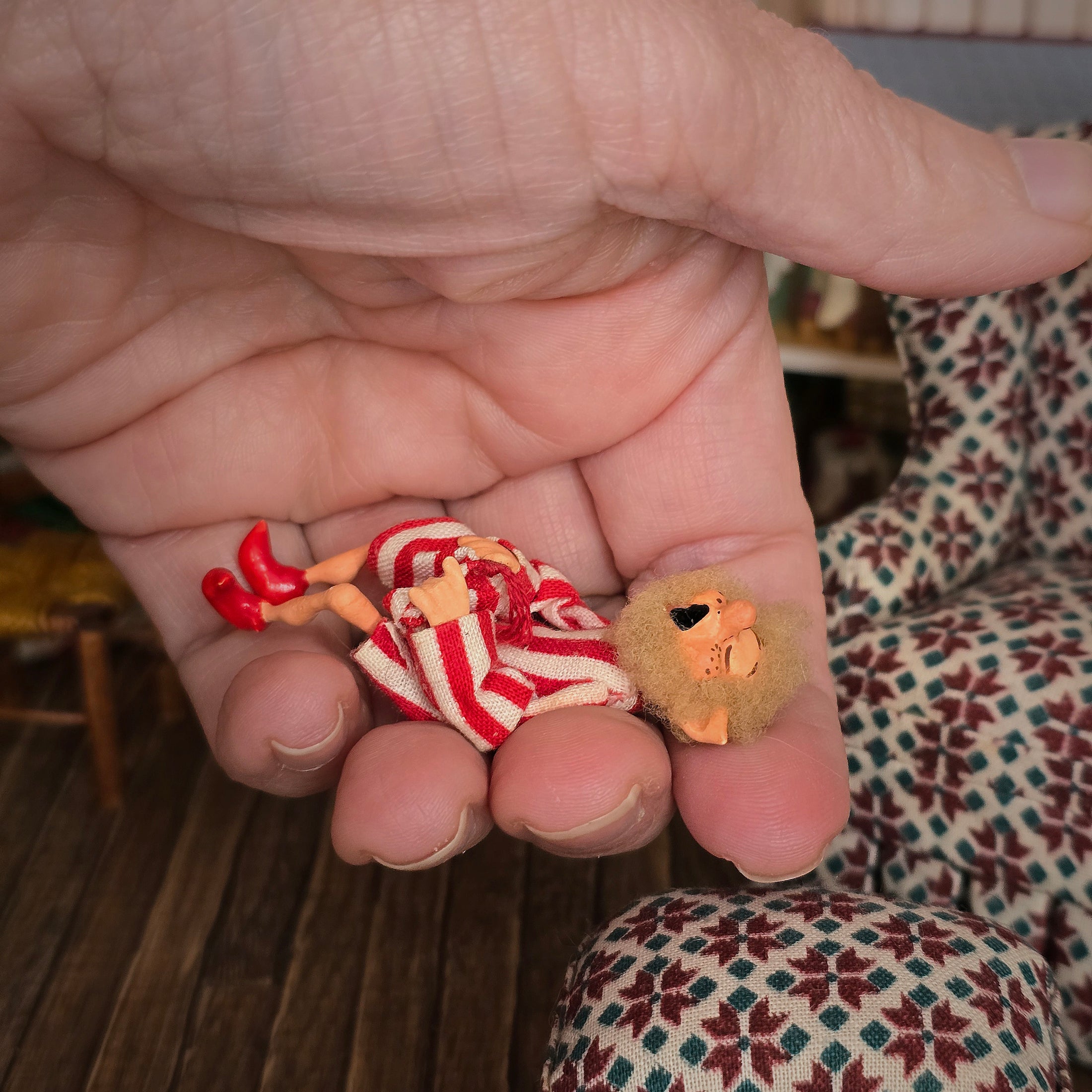 Yawning elf doll, held in a hand.