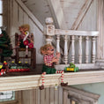 Load image into Gallery viewer, Grinning Elf Christmas Doll Cynthia Baron with Christmas toys in the background
