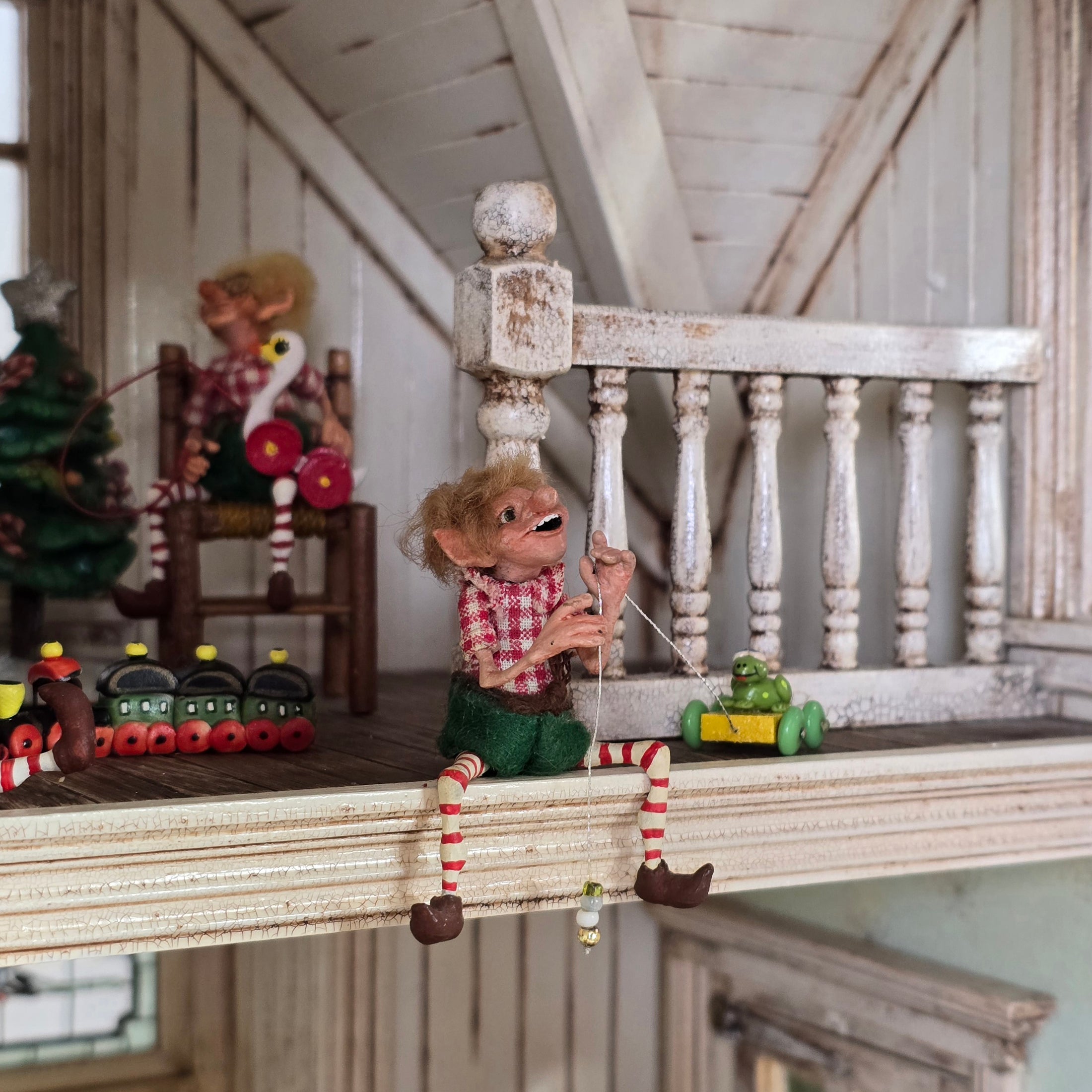Grinning Elf Christmas Doll Cynthia Baron with Christmas toys in the background