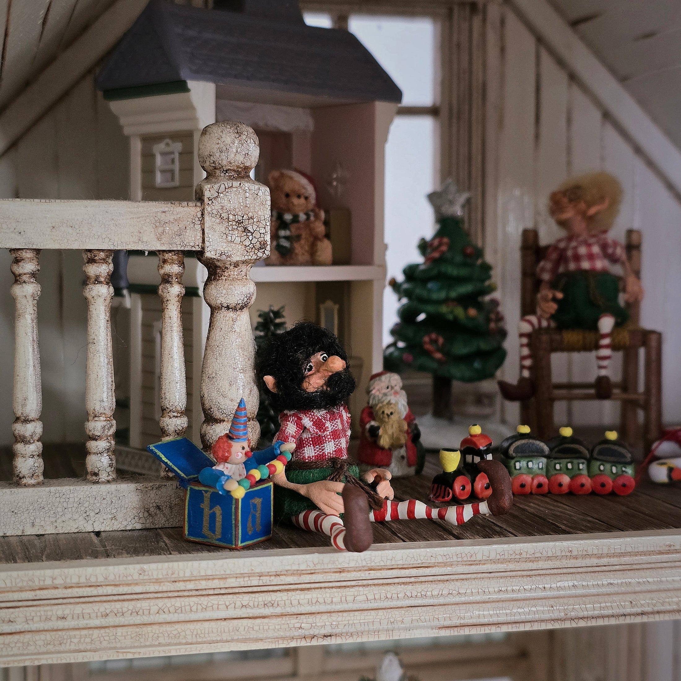 black-bearded elf dollhouse doll surrounded by toys