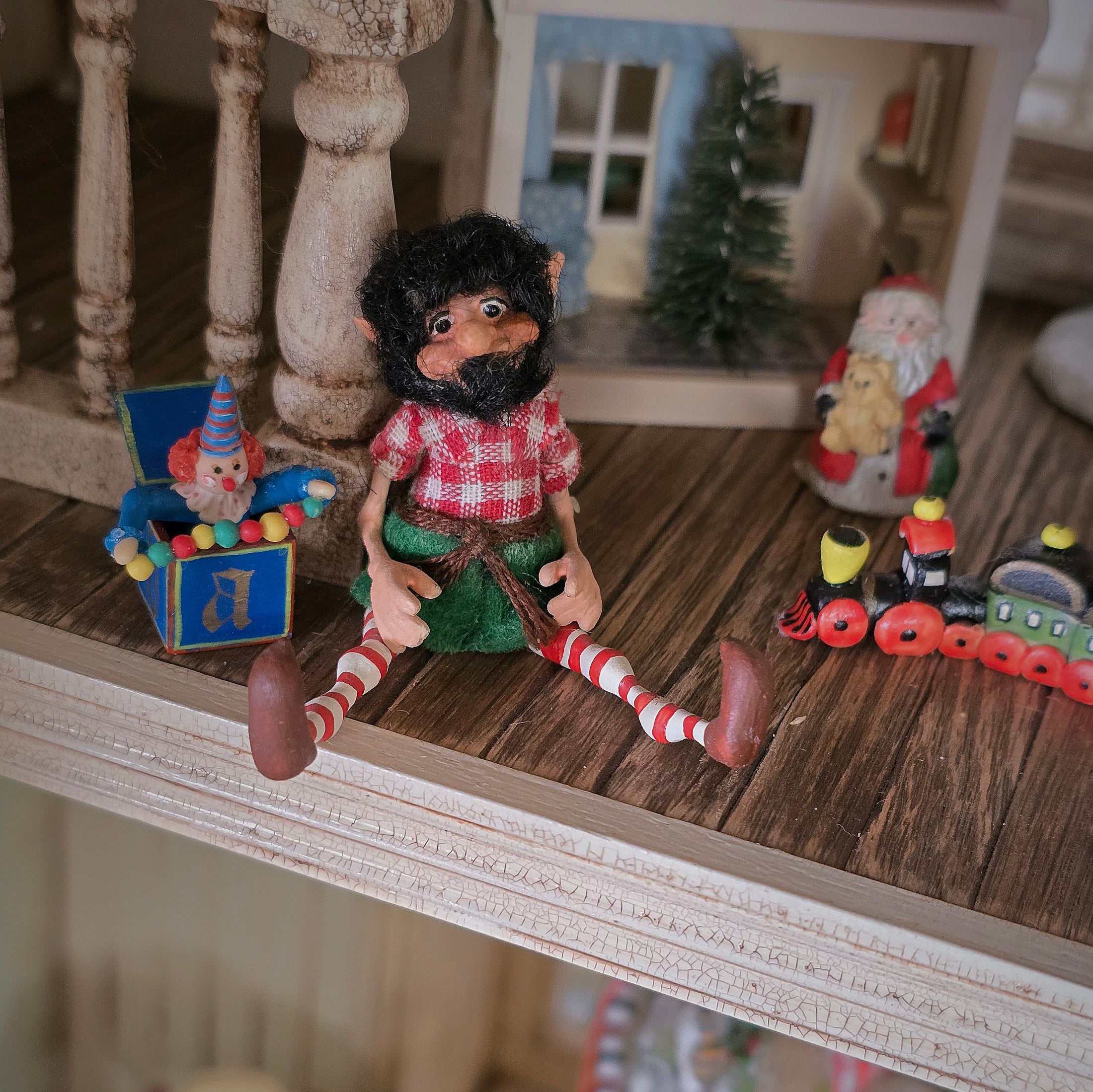 black-bearded elf dollhouse doll, surrounded by toys