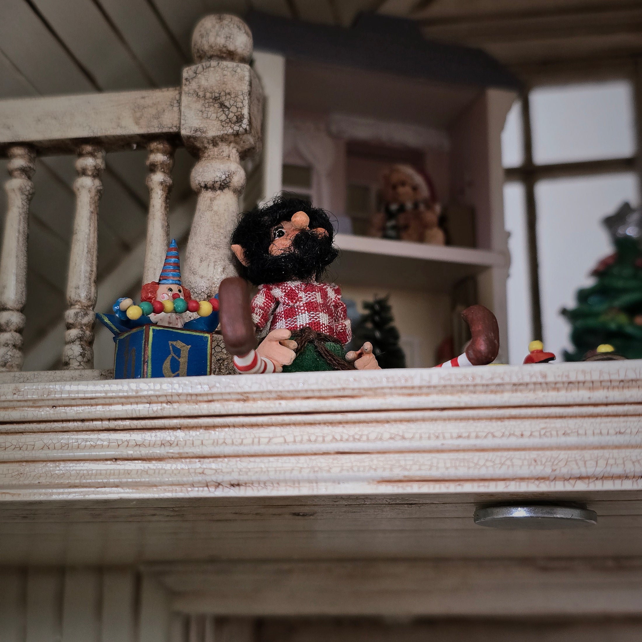 black-bearded elf dollhouse doll seated up in a loft