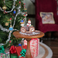 Load image into Gallery viewer, chocolate roll miniature cake with snowman on top, on a table
