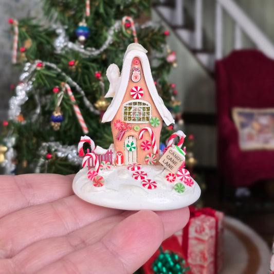 Candy cane gingerbread house in hand