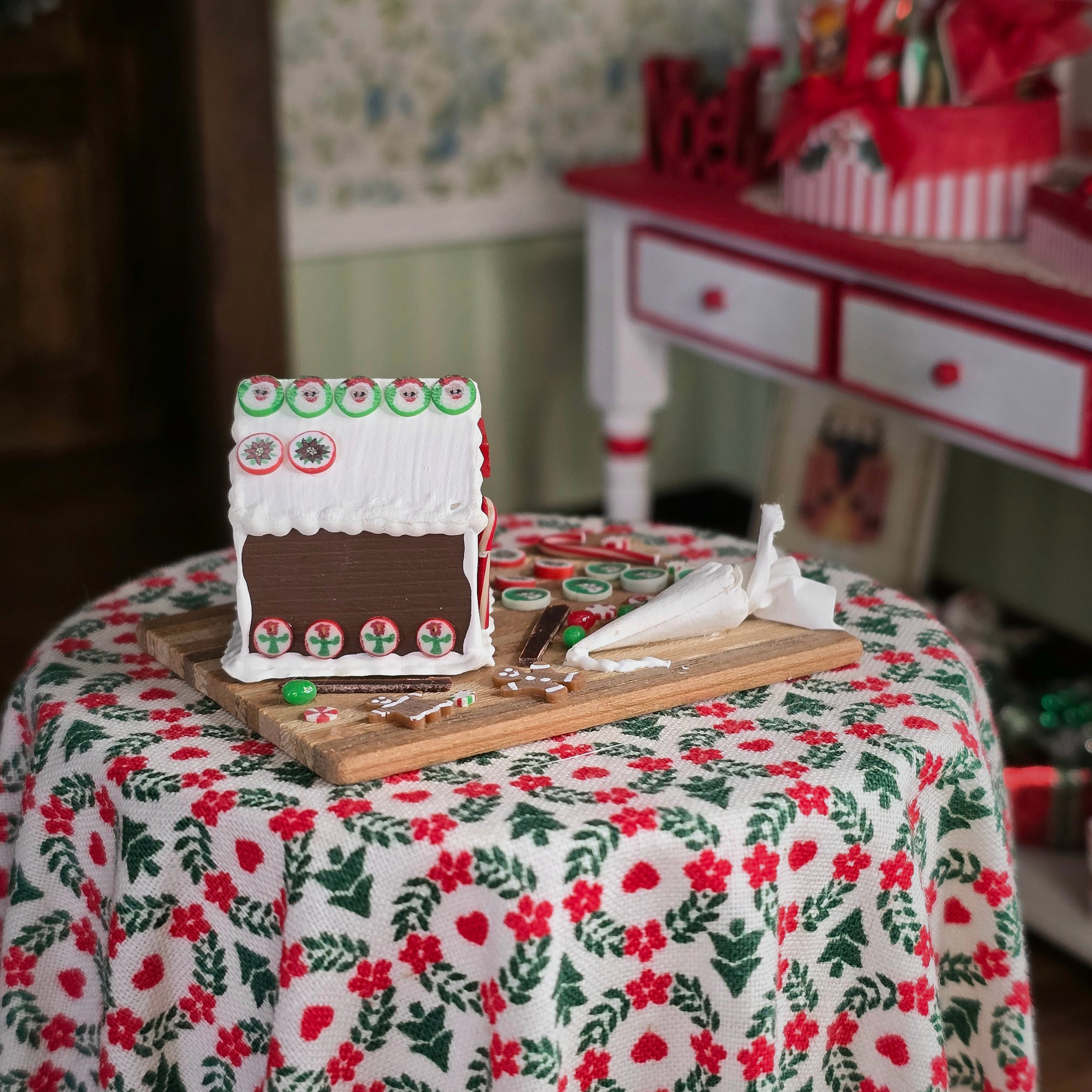 Gingerbread house on a floral tablecloth with a blurred background