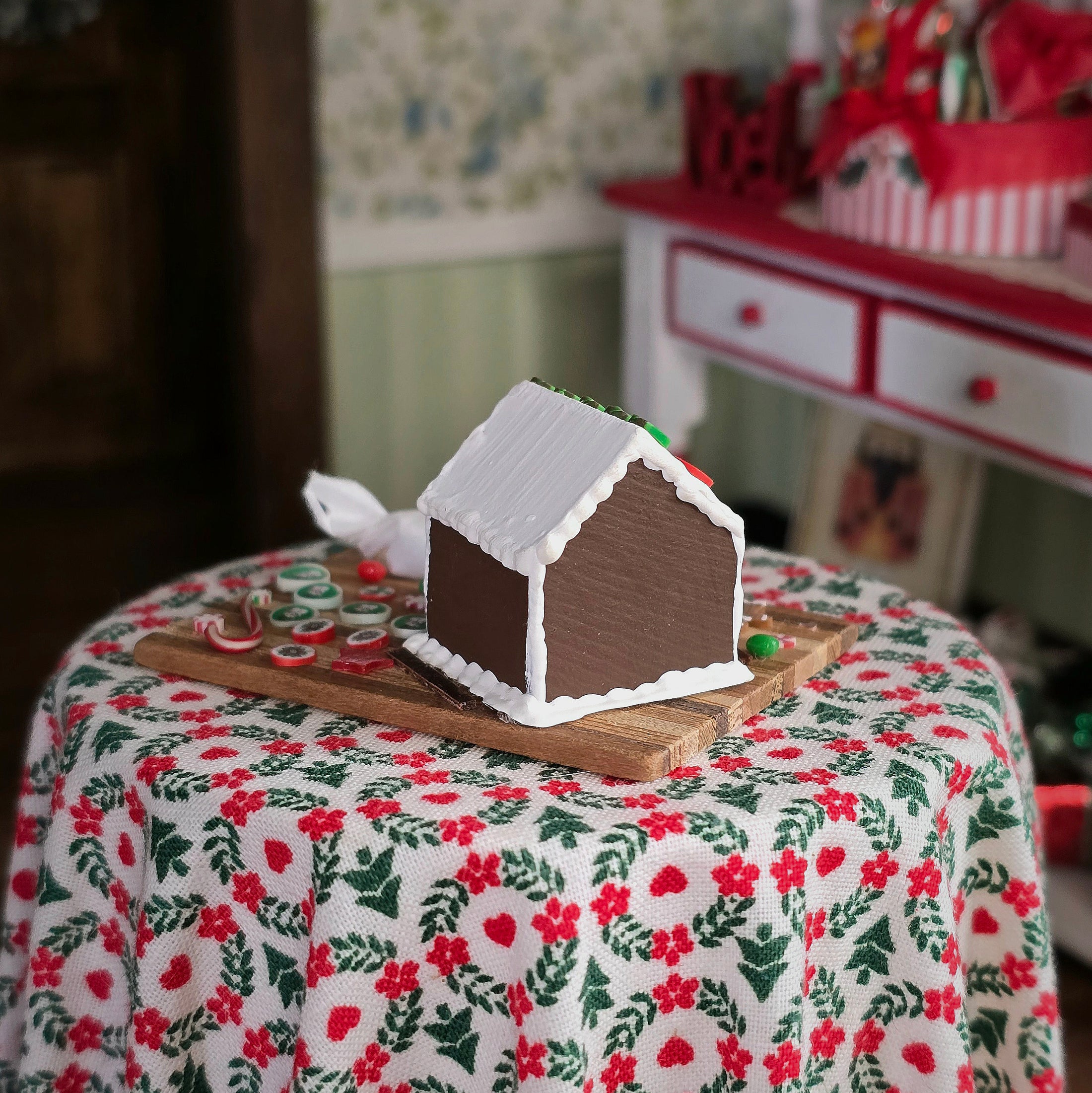 Gingerbread house on a floral tablecloth with a blurred background