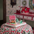 Load image into Gallery viewer, Gingerbread house on a decorative tablecloth with a festive background
