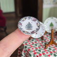 Load image into Gallery viewer, Decorative plate with floral border and tree design held by a hand, with more plates in the background.
