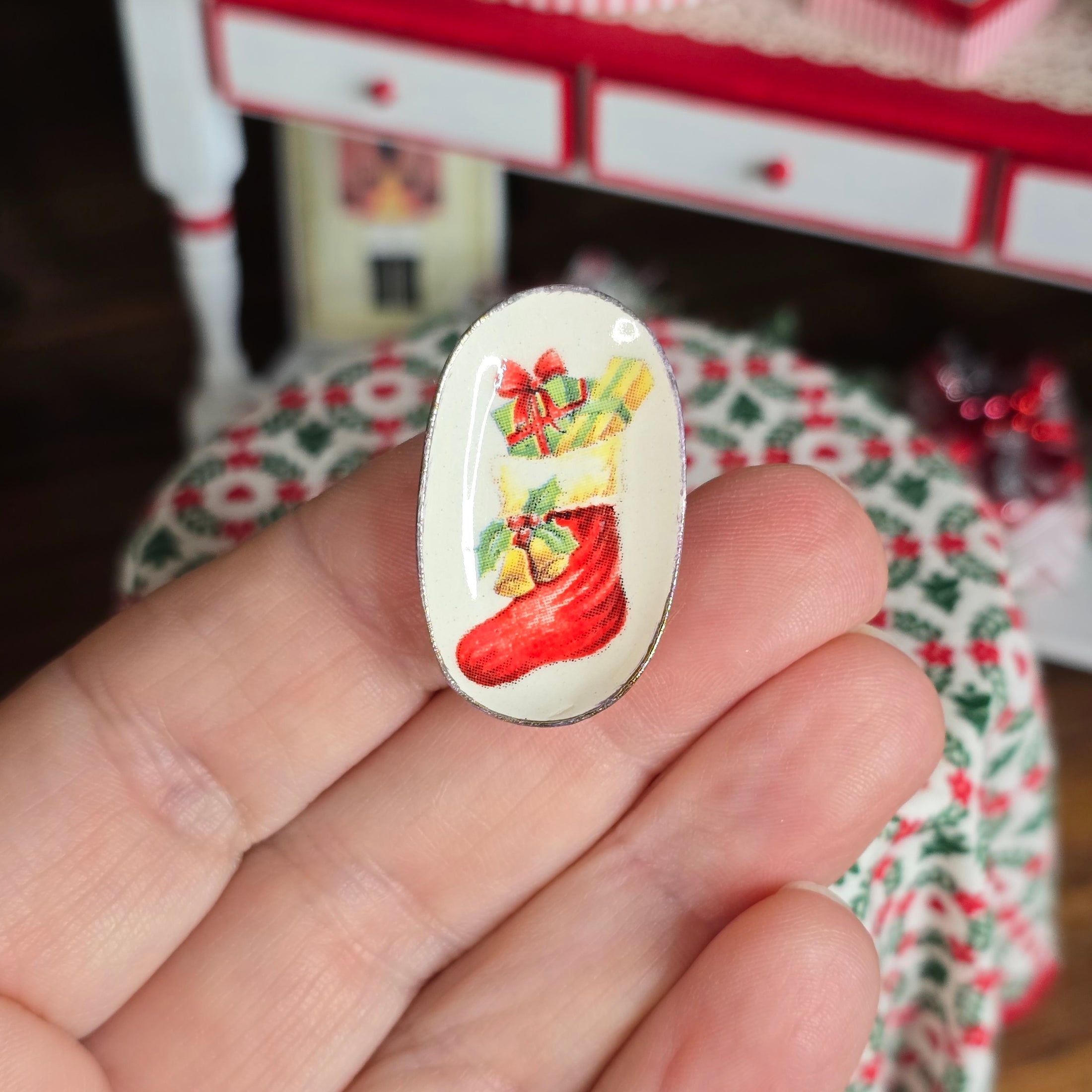 Small decorative plate with a Christmas design held between fingers