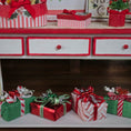 Load image into Gallery viewer, Decorative Christmas scene with red and green gift boxes on a shelf.
