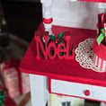 Load image into Gallery viewer, Red 'Noel' sign on a Christmas-themed table with decorations.
