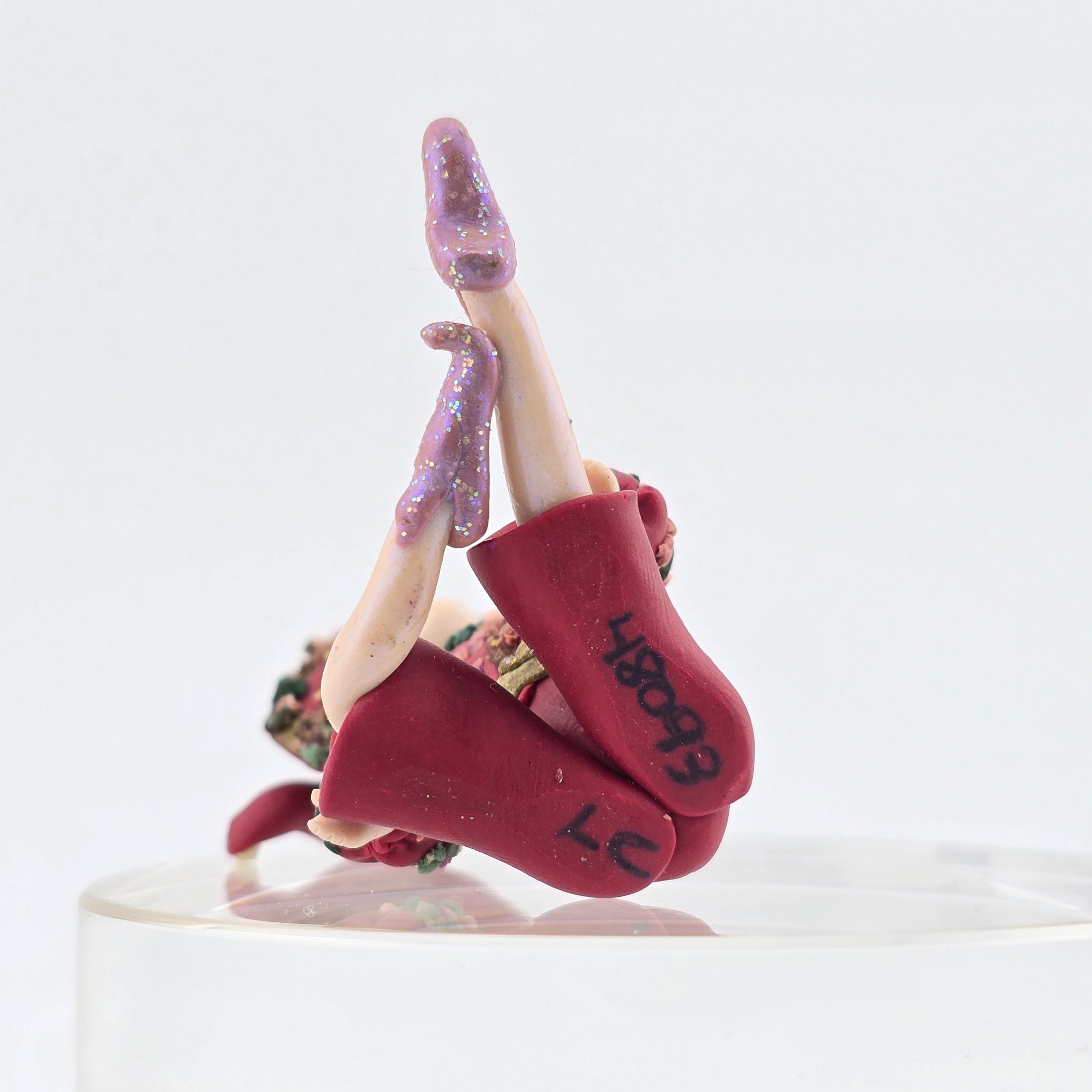 signed underside of elf boy doll in pink suit