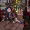 Load image into Gallery viewer, Sculpted clay elf boy doll wearing a purple outfit sitting on a hand
