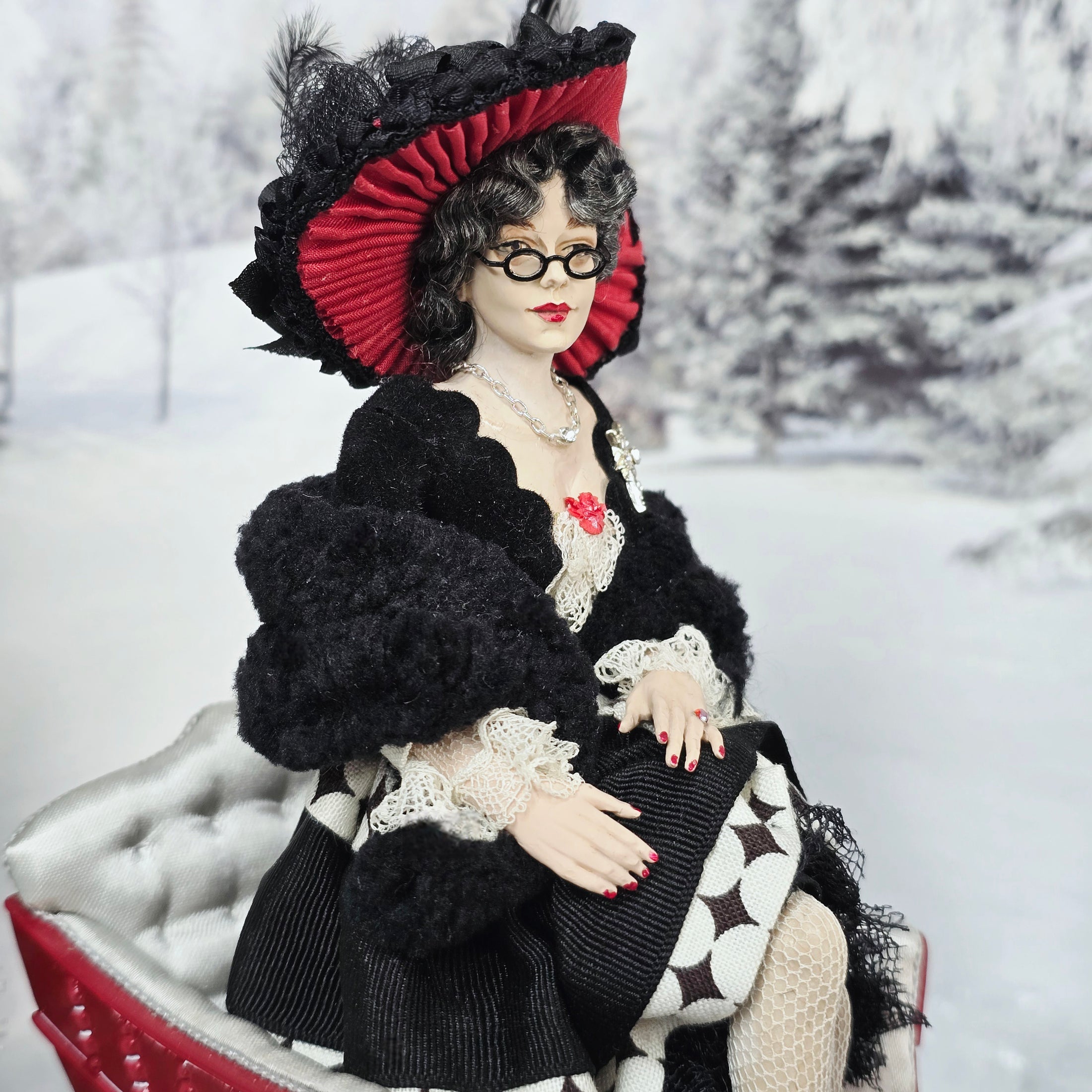 “Winter Lady” Doll  in a black and red outfit with a hat, sitting in a sleigh