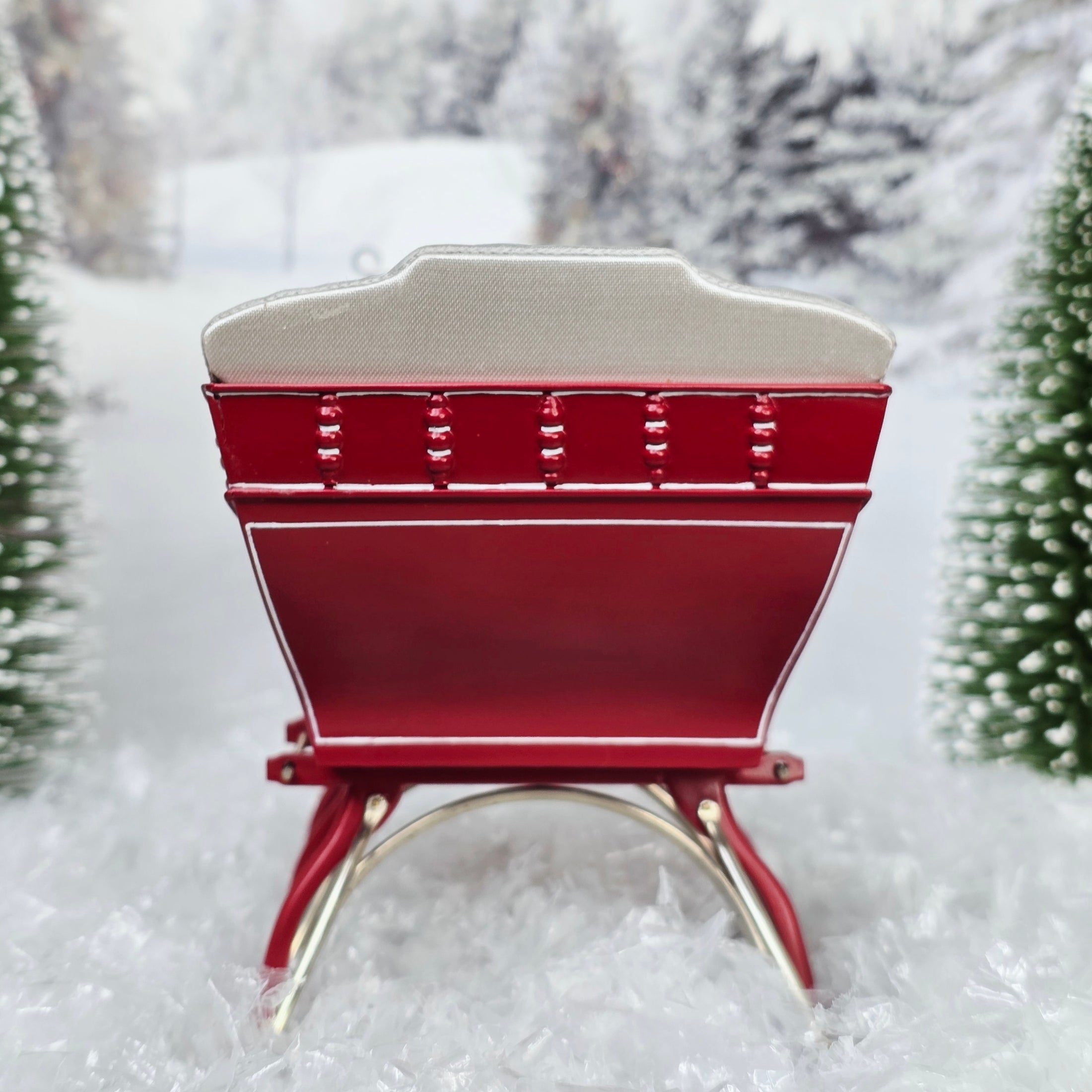 Red sleigh with white seats in a snowy landscape, back view